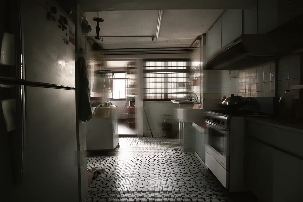 Dimly lit retro kitchen with mosaic tile flooring, refrigerator, and stove, capturing everyday life in a traditional Singapore home.